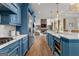 Bright, eat-in kitchen features blue cabinets, stainless steel appliances, and hardwood flooring at 770 Tralee Dr, Fayetteville, GA 30215