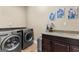 Well-equipped laundry room featuring modern stainless steel appliances and granite countertop with cabinets at 770 Tralee Dr, Fayetteville, GA 30215