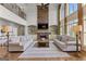 Open-concept living room with a stone fireplace, built-in shelving, sofas, and hardwood floors at 770 Tralee Dr, Fayetteville, GA 30215