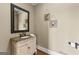 Charming powder room with decorative mirror and a granite-topped vanity at 770 Tralee Dr, Fayetteville, GA 30215
