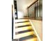 Staircase with wooden steps, black railing, and patterned wallpaper at 2425 Wood Valley Dr, Morrow, GA 30260