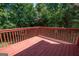 Spacious wooden deck with red railing, overlooking green trees and foliage at 10074 Tara Glynn Dr, Hampton, GA 30228