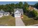 Charming two-story home with a well-manicured lawn and a two-car garage and mature trees in the background at 10074 Tara Glynn Dr, Hampton, GA 30228