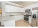 Well-lit kitchen with white cabinets, granite counters and stainless-steel appliances at 10074 Tara Glynn Dr, Hampton, GA 30228