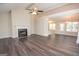 Spacious living room with wood-look flooring, fireplace, large window, ceiling fan, and bright open floor plan at 10074 Tara Glynn Dr, Hampton, GA 30228