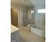 Bright bathroom featuring a glass-enclosed shower, soaking tub, and tile flooring at 136 Paulownia Cir, Mcdonough, GA 30253