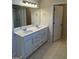 Well-lit bathroom with double vanity sinks, modern fixtures, and tile floors at 136 Paulownia Cir, Mcdonough, GA 30253