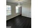 Bedroom with hardwood floors, windows, and a ceiling light at 136 Paulownia Cir, Mcdonough, GA 30253