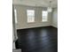 Bedroom with three windows and dark wood-look floors at 136 Paulownia Cir, Mcdonough, GA 30253