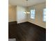 Bright dining area with dark wood floors, pendant lighting, and large windows at 136 Paulownia Cir, Mcdonough, GA 30253