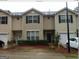 Inviting townhome featuring black shutters, white trim and a well-maintained front yard and garage at 2320 Coach Way, Jonesboro, GA 30236