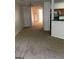 An open-concept living space with neutral carpet, white walls, and a view leading to the kitchen at 2320 Coach Way, Jonesboro, GA 30236
