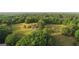 Aerial view of the property showing a house nestled among mature trees, with green grass at 877 Honey Creek Rd, Mcdonough, GA 30252