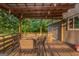 Wooden back porch area with an outdoor dining set and strung lights above at 877 Honey Creek Rd, Mcdonough, GA 30252