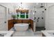 Elegant bathroom featuring a soaking tub, a glass shower, and wood-paneled walls at 877 Honey Creek Rd, Mcdonough, GA 30252