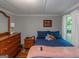 A well-lit bedroom with blue bedding, hardwood floors and a view to the outside at 877 Honey Creek Rd, Mcdonough, GA 30252