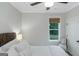 Neutrally decorated bedroom featuring a ceiling fan, and a window dressed with woven shades at 877 Honey Creek Rd, Mcdonough, GA 30252