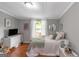 Bright bedroom featuring hardwood floors, neutral walls, and a sunlit window at 877 Honey Creek Rd, Mcdonough, GA 30252