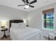 Cozy bedroom with a ceiling fan, a decorative headboard, and a bright window with a view at 877 Honey Creek Rd, Mcdonough, GA 30252