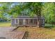 Charming single-story home featuring a welcoming front porch and mature shade trees in a tranquil setting at 877 Honey Creek Rd, Mcdonough, GA 30252