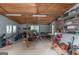 View of the garage with storage shelving, workbenches and overhead ceiling fan at 877 Honey Creek Rd, Mcdonough, GA 30252