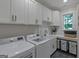 Bright laundry room with white cabinetry, modern appliances and a practical design at 877 Honey Creek Rd, Mcdonough, GA 30252