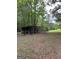 Outbuilding with a chain link fence and an open field behind the structure surrounded by trees at 877 Honey Creek Rd, Mcdonough, GA 30252
