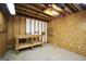 Unfinished basement with exposed beams, concrete floor, and a workbench at 40 Derby Country Dr, Ellenwood, GA 30294