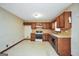 This kitchen features wood cabinets and vintage-style flooring and wallpaper at 40 Derby Country Dr, Ellenwood, GA 30294