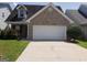 Charming brick home with a two-car garage and well-maintained front lawn and landscaping at 2075 Tussahaw Xing, Mcdonough, GA 30252