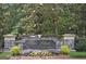 Stone community sign for 'The Point On Lake Kedron' surrounded by colorful flowerbeds and greenery at 113 Regents Sq, Peachtree City, GA 30269