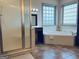 Bathroom with a soaking tub, framed window, separate shower and tile flooring at 232 Darwish Dr, Mcdonough, GA 30252