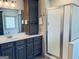 Bathroom featuring a dark wood vanity with drawers, a large mirror and a glass-enclosed shower at 232 Darwish Dr, Mcdonough, GA 30252