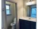 Well-lit bathroom with dark cabinets, a large mirror and separate toilet room at 232 Darwish Dr, Mcdonough, GA 30252