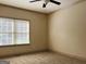 A spacious, carpeted bedroom with a ceiling fan and natural light from a window at 232 Darwish Dr, Mcdonough, GA 30252