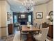 Formal dining room showcasing elegant chandelier and seamless transition to the living room fireplace at 232 Darwish Dr, Mcdonough, GA 30252