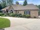 Sprawling single-story home with a circular driveway, manicured landscaping, and a brick and stone facade at 232 Darwish Dr, Mcdonough, GA 30252