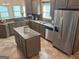 View of the kitchen with stainless steel appliances, an island, and brown cabinets at 232 Darwish Dr, Mcdonough, GA 30252