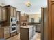 Spacious kitchen with stainless steel appliances, tile floors, granite counters, light brown cabinets, and brick fireplace at 232 Darwish Dr, Mcdonough, GA 30252