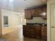 Basement kitchenette with dark wood cabinets, sink, and views into a spacious living area at 232 Darwish Dr, Mcdonough, GA 30252