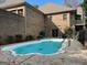 Backyard view of a small in-ground pool surrounded by concrete with fence and brick house in background at 232 Darwish Dr, Mcdonough, GA 30252