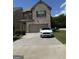 Two-story home with light brick, a two-car garage, and a concrete driveway at 11909 Lovejoy Crossing Blvd, Hampton, GA 30228