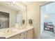 A clean bathroom showcases a double vanity with framed mirror and decoratively tiled shower behind an open door at 2693 Blairsden Nw Pl, Kennesaw, GA 30144
