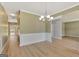 Elegant dining room with wainscoting, wood floors, and a modern chandelier at 340 Aster Ridge Trl, Peachtree City, GA 30269