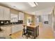 Eat-in kitchen with white cabinets, granite countertops, black backsplash and island with seating at 340 Aster Ridge Trl, Peachtree City, GA 30269