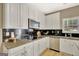 Updated kitchen with granite countertops, stainless steel appliances, and white cabinets against a black backsplash at 340 Aster Ridge Trl, Peachtree City, GA 30269