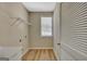 Laundry room featuring wood-look flooring, window, louvred door, and utility sink at 340 Aster Ridge Trl, Peachtree City, GA 30269