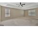 Bright primary bedroom featuring tray ceilings, ceiling fan, and multiple windows at 340 Aster Ridge Trl, Peachtree City, GA 30269