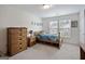 Cozy bedroom features a chest of drawers, nightstand, and natural light at 1560 Avalon Creek Rd, Sugar Hill, GA 30518