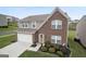 Two-story brick and siding home featuring a well-manicured lawn and a two-car garage at 1560 Avalon Creek Rd, Sugar Hill, GA 30518